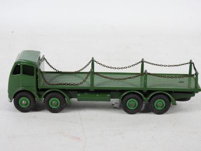 un petit camion jouet vert avec des chaînes attachées à l'arrière