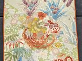 a close up of a table runner with flowers and birds on it