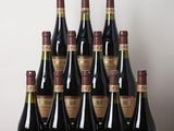 several bottles of wine are lined up on a wooden table