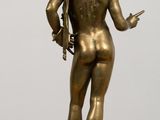 bronze statue of a man holding a sword on a wooden table