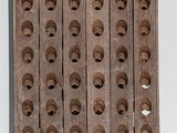 a wooden rack with holes on it on a white surface