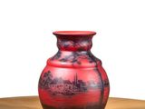 a red vase sitting on top of a wooden table