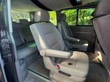 l'intérieur d'une camionnette, avec la porte ouverte et le siège passager relevé