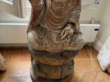 a statue of a buddha sitting on top of a stool