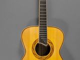 un gros plan d'une guitare acoustique sur fond gris