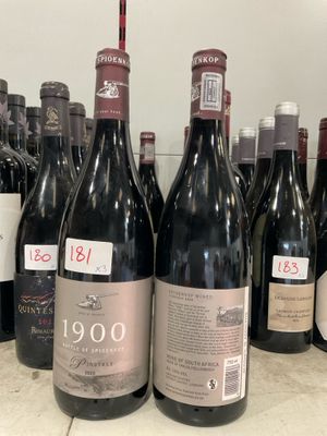 plusieurs bouteilles de vin rouge sont alignées sur un comptoir