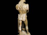 statue of a man sitting on a stool with a hat on