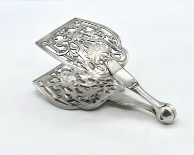 a silver spoon that is sitting on a white surface