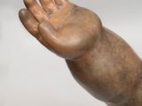 a statue of a hand holding something in it ' s right hand