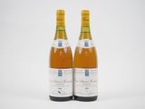 deux bouteilles de vin posées l'une à côté de l'autre sur une surface blanche