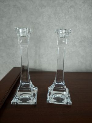 deux bougeoirs en verre transparent posés sur une table en bois