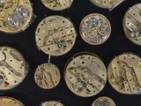 many different types of watches on a black surface