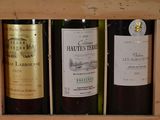 three bottles of wine sitting in a wooden box