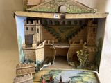 une petite maquette de château dans une boîte posée sur une table