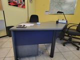 un bureau et des chaises dans une pièce où est accrochée une carte au mur