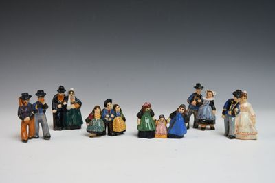 de nombreuses figurines représentant des personnes debout les unes à côté des autres sur une surface blanche