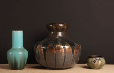 trois vases posés sur une table l'un à côté de l'autre