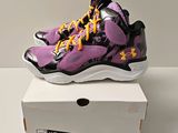 chaussures de basket Under Armour violettes et noires présentées dans une boîte blanche