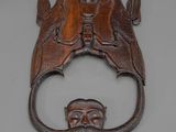 une image représentant un heurtoir de porte en bois orné d'un visage d'homme