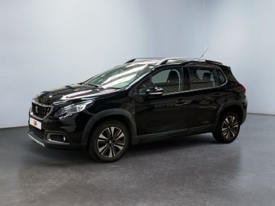 un SUV noir garé dans une pièce aux murs blancs