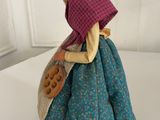 a figurine of a woman in a blue dress and a pink hat