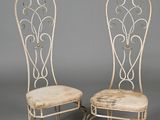 pair of antique wrought chairs with upholstered seat cushions