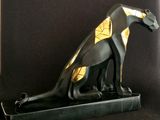 statue of an egyptian cat on a black base with gold accents