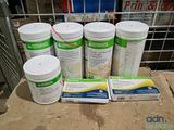 six bouteilles de protéines posées sur une table à côté d'un carton de lait