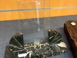 a black and white marble display case and a brown suitcase