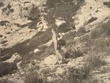 une photo en noir et blanc d'un homme debout sur une colline rocheuse