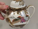 a person holding a tea pot with a picture on it