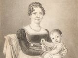 an old black and white photo of a woman holding a baby