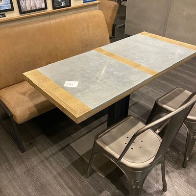 une table avec un banc et deux chaises dans une pièce
