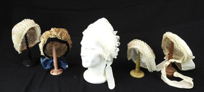 quatre figurines représentant des personnages coiffés de chapeaux et dotés d'ailes, sur fond noir