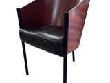 La chaise est en bois et en cuir, avec une assise en cuir noir