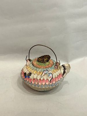 a small tea pot with a bird on it