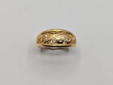 gros plan d'une bague en or avec des diamants sur une surface blanche