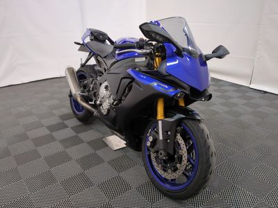 une photo d'une moto bleue garée sur un sol à damier
