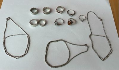 beaucoup de bijoux en argent sur une table blanche