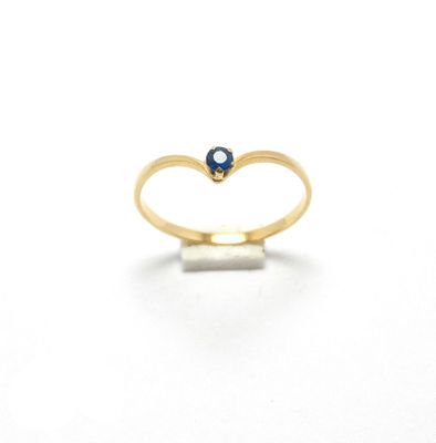 une image représentant une bague en or avec une pierre bleue au centre