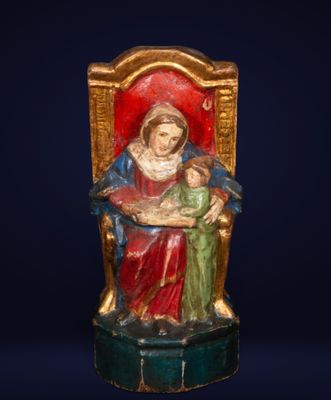 an image of a statue of a woman holding a child on a throne