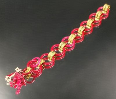 bracelet à maillons roses et dorés orné d'une breloque en forme de croix