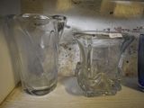 three glass vases sitting on a shelf next to each other
