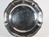 an antique silver plate on a stand on a white background
