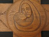 carvings of a baby in a manger on a wooden cross