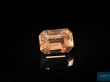 an orange sapphire stone on a black surface