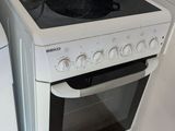 un four de cuisine blanc posé à côté d'un lave-linge et d'un sèche-linge