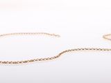 a close up of a gold chain bracelet on a white surface
