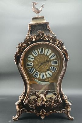 a clock that has a bird on top of it