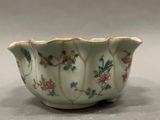 a white bowl with flowers on it sitting on a table